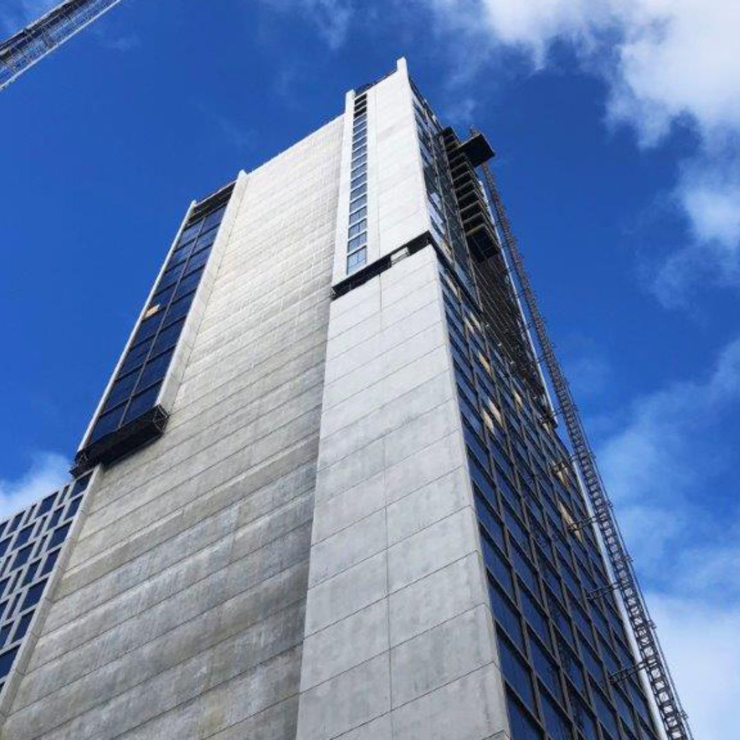 Tall concrete and glass high-rise hotel development under construction in New Zealand, featuring Passive Fire NZ’s compliant passive fire protection systems for a dual-hotel design.