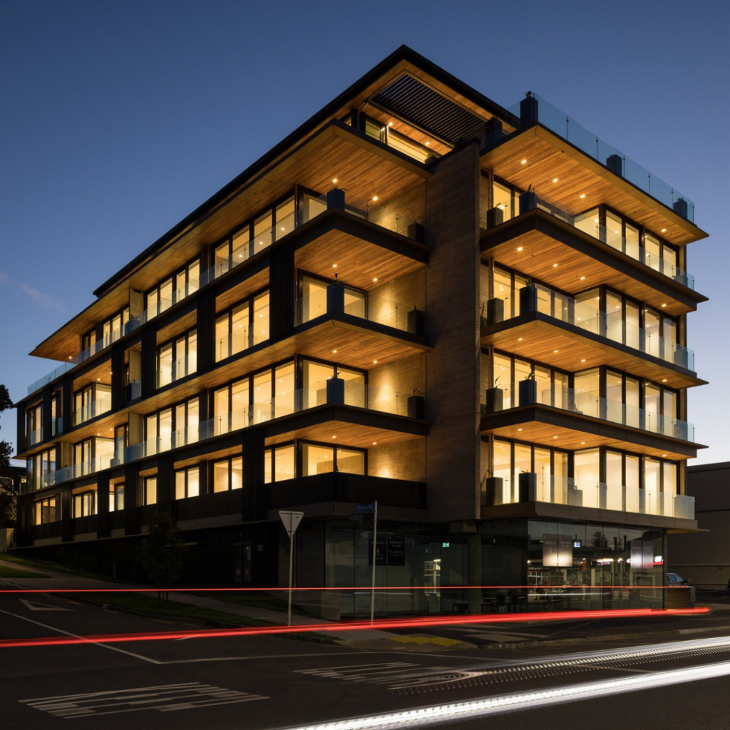 Milford 110 Luxury Apartments – Passive Fire NZ Project Exterior view of Milford 110 luxury apartment complex at dusk, showing the premium multi-level architecture with floor-to-ceiling glass, protected by Passive Fire NZ’s compliant fire-stopping systems.